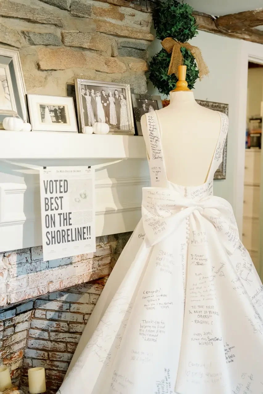 Wedding gown with handwritten messages on display by a fireplace